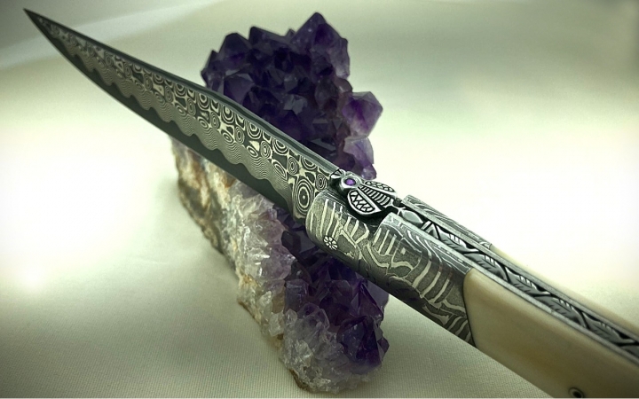 COUTEAU LAGUIOLE CISELE LAME ET MITRES DAMAS MOSAIQUE MANCHE IVOIRE DE PHACOCHERE ARGENT ET NACRE