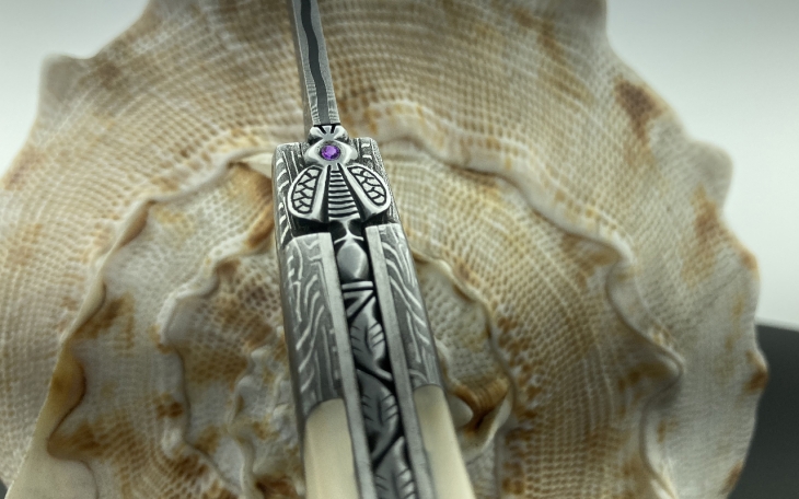 COUTEAU LAGUIOLE CISELE LAME ET MITRES DAMAS MOSAIQUE MANCHE IVOIRE DE PHACOCHERE ARGENT ET NACRE